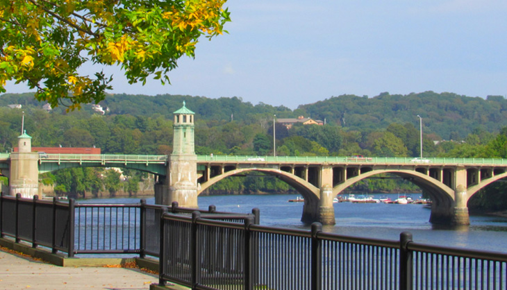 A pleasant town decorated with foliage and a bridge over water